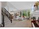 Bright and open living room with a fireplace, large windows and stair access to upper level at 12054 E Lake Cir, Greenwood Village, CO 80111