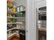Walk-in pantry offering ample storage space with shelving and easy access to stainless steel ovens at 12054 E Lake Cir, Greenwood Village, CO 80111