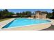 A large, sparkling blue pool sits outside a residential building, shaded by stylish tan canopies at 12054 E Lake Cir, Greenwood Village, CO 80111