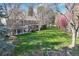 Expansive backyard featuring a large lawn, mature trees, and covered patio with ample seating space at 4 Brookside Dr, Greenwood Village, CO 80121