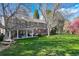 Large backyard with a covered patio, seating, and mature trees at 4 Brookside Dr, Greenwood Village, CO 80121