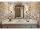 Stylish powder room featuring a marble vanity and a decorative mirror at 4 Brookside Dr, Greenwood Village, CO 80121