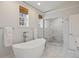 Bright bathroom featuring a soaking tub, marble shower, and modern fixtures at 4 Brookside Dr, Greenwood Village, CO 80121
