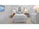 Bright bedroom with a queen-sized bed, side tables, and a writing desk at 4 Brookside Dr, Greenwood Village, CO 80121
