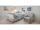Cozy bedroom with a queen-sized bed, an accent chair, and lots of natural light at 4 Brookside Dr, Greenwood Village, CO 80121