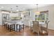 Open-concept kitchen featuring stainless steel appliances, white cabinetry, hardwood floors and breakfast area at 4 Brookside Dr, Greenwood Village, CO 80121