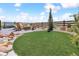 Outdoor backyard featuring a fire pit with chairs, a hot tub, landscaping rocks, and an artifical turf area at 3038 Blithe Pt, Castle Rock, CO 80108