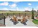 Outdoor living space with a stone fire pit surrounded by chairs and a view of the yard and neighborhood at 3038 Blithe Pt, Castle Rock, CO 80108