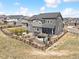 An elevated rear view of a fenced home featuring outdoor living area, patio, hot tub and landscaping at 3038 Blithe Pt, Castle Rock, CO 80108
