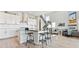 Modern kitchen featuring sleek white cabinets, a breakfast bar, and a seamless connection to the living area at 3038 Blithe Pt, Castle Rock, CO 80108