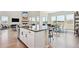 Bright open-concept kitchen featuring an island, hardwood floors, and large windows with neighborhood views at 3038 Blithe Pt, Castle Rock, CO 80108