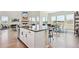 Bright open-concept kitchen featuring an island, hardwood floors, and large windows with neighborhood views at 3038 Blithe Pt, Castle Rock, CO 80108