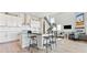 Stylish kitchen flowing into a living space, featuring bar seating and stainless steel appliances at 3038 Blithe Pt, Castle Rock, CO 80108
