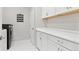 Bright laundry room with white cabinets, a folding counter, and a front-loading washer at 3038 Blithe Pt, Castle Rock, CO 80108