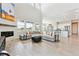 Spacious living room with a fireplace, large windows, and open floor plan flows into the kitchen at 3038 Blithe Pt, Castle Rock, CO 80108