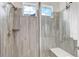 Walk-in shower with gray tile and built-in seat at 8901 S Ukraine Ct, Aurora, CO 80016