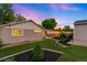A beautiful backyard featuring landscaped garden beds, lush grass, and a cozy patio area, ideal for relaxation at 5125 Umatilla St, Denver, CO 80221