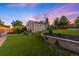 Spacious backyard with lush green lawn, retaining walls, and a detached structure perfect for recreation or storage at 5125 Umatilla St, Denver, CO 80221