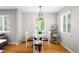 Charming dining area with a glass-top table, white chairs, and a decorative shelf, ideal for Gathering meals at 5125 Umatilla St, Denver, CO 80221
