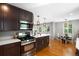 Modern kitchen with stainless steel appliances, dark wood cabinets, and a seamless flow to the dining and living areas at 5125 Umatilla St, Denver, CO 80221