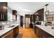 Updated kitchen featuring stainless steel appliances, dark cabinetry, light countertops and hardwood flooring at 5125 Umatilla St, Denver, CO 80221