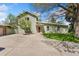 Light green home with well-maintained lawn, showcasing a charming exterior and large driveway at 185 S Hoyt St, Lakewood, CO 80226