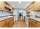 Galley kitchen featuring wooden cabinets, tile floors, and white appliances at 185 S Hoyt St, Lakewood, CO 80226