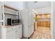 Galley kitchen with white appliances, wood cabinets, and tile floors at 185 S Hoyt St, Lakewood, CO 80226