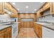 Galley kitchen with wooden cabinets, white appliances and recessed lighting at 185 S Hoyt St, Lakewood, CO 80226