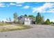Charming two-story home features a two-car garage and a fenced yard, nestled amidst mature trees on a sunny day at 2460 Eileen Way, Parker, CO 80138