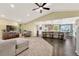 Spacious living room with a vaulted ceiling, a skylight, hardwood floors, and a seamless flow to the kitchen area at 2460 Eileen Way, Parker, CO 80138