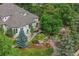 Aerial view of home with mature trees, outdoor patio with seating and a well manicured yard at 1999 Champions Cir, Castle Rock, CO 80104