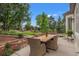 Outdoor patio with seating area and fountain feature, surrounded by lush landscaping and mature trees at 1999 Champions Cir, Castle Rock, CO 80104