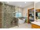 Bright bathroom featuring a glass shower with tile surround and a soaking tub at 1999 Champions Cir, Castle Rock, CO 80104