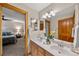 Bright bathroom with double vanity sinks and a view into the bedroom at 1999 Champions Cir, Castle Rock, CO 80104
