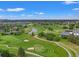 Expansive aerial view of a lush green golf course with rolling hills, sand traps, and a scenic water feature at 1999 Champions Cir, Castle Rock, CO 80104