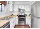 Kitchen with stainless steel appliances, white cabinets, and wood countertops at 1595 Macarthur Dr, Boulder, CO 80303