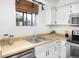 Bright kitchen featuring stainless steel sink, white cabinets and appliances, and butcher block countertops at 1595 Macarthur Dr, Boulder, CO 80303