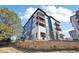 Modern apartment building with multiple balconies, set against a blue sky and stone wall at 487 Interlocken Blvd # 307, Broomfield, CO 80021