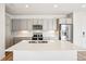 Modern kitchen with stainless steel appliances, a large center island with quartz countertop, and ample cabinet space at 487 Interlocken Blvd # 307, Broomfield, CO 80021