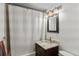 Bright bathroom with a shower tub, granite top vanity, and updated light fixtures at 2582 Beech Ct, Golden, CO 80401