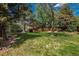 Expansive backyard with a well-kept lawn, mature trees, and a covered patio area at 7076 S Niagara Ct, Centennial, CO 80112