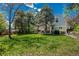 Spacious backyard with a lush green lawn, patio area, and mature trees at 7076 S Niagara Ct, Centennial, CO 80112