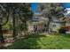 Picturesque backyard featuring a covered patio, mature trees, and plenty of green space at 7076 S Niagara Ct, Centennial, CO 80112