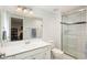Bathroom with a white vanity and shower and a big mirror reflecting a view of the bedroom at 7076 S Niagara Ct, Centennial, CO 80112