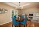 Dining area with access to living space, featuring a round table and four blue chairs, with a view of the fireplace at 7076 S Niagara Ct, Centennial, CO 80112