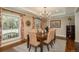 Inviting dining room with chandelier, wooden table, and chairs, bathed in natural light from a large window at 7076 S Niagara Ct, Centennial, CO 80112