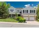 Beautiful two-story house with a well-maintained lawn and attached two-car garage, framed by lush greenery at 7076 S Niagara Ct, Centennial, CO 80112