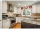 Updated kitchen featuring modern appliances, granite counters, custom cabinetry, and a functional center island at 7076 S Niagara Ct, Centennial, CO 80112