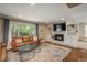 Cozy living room with a brick fireplace, built-in shelving, and a large window at 7076 S Niagara Ct, Centennial, CO 80112